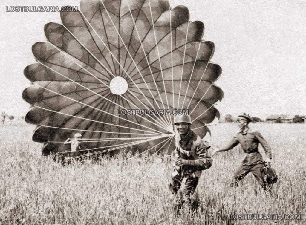 Лятото на 1944, български парашутист след скок в пълно бойно снаряжение. Войник и момче помагат за парашута