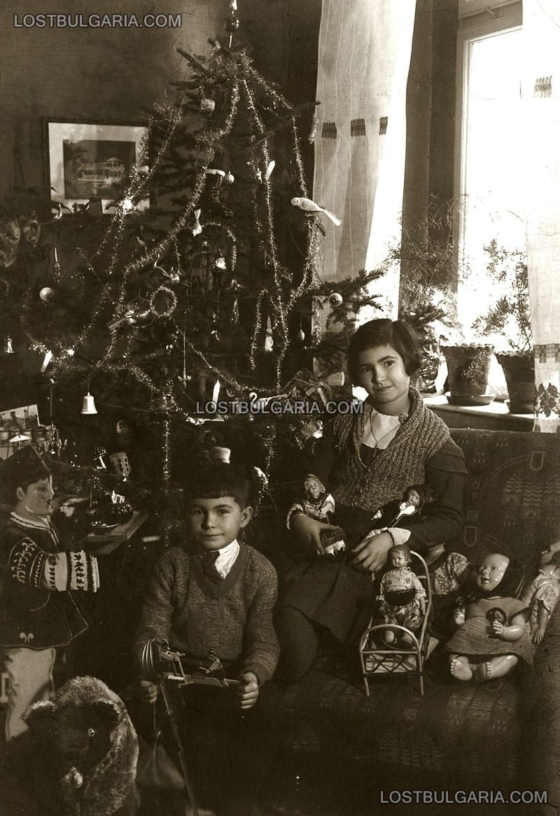 Коледа, две деца с подаръците си пред коледната елха, 40-те години на ХХ век