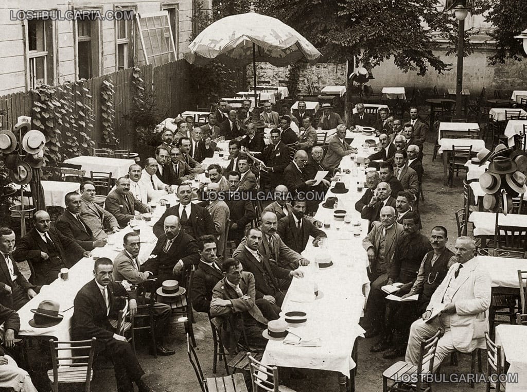 Група мъже, събрани на по халба бира в двора на бирария, 20-те години на ХХ век