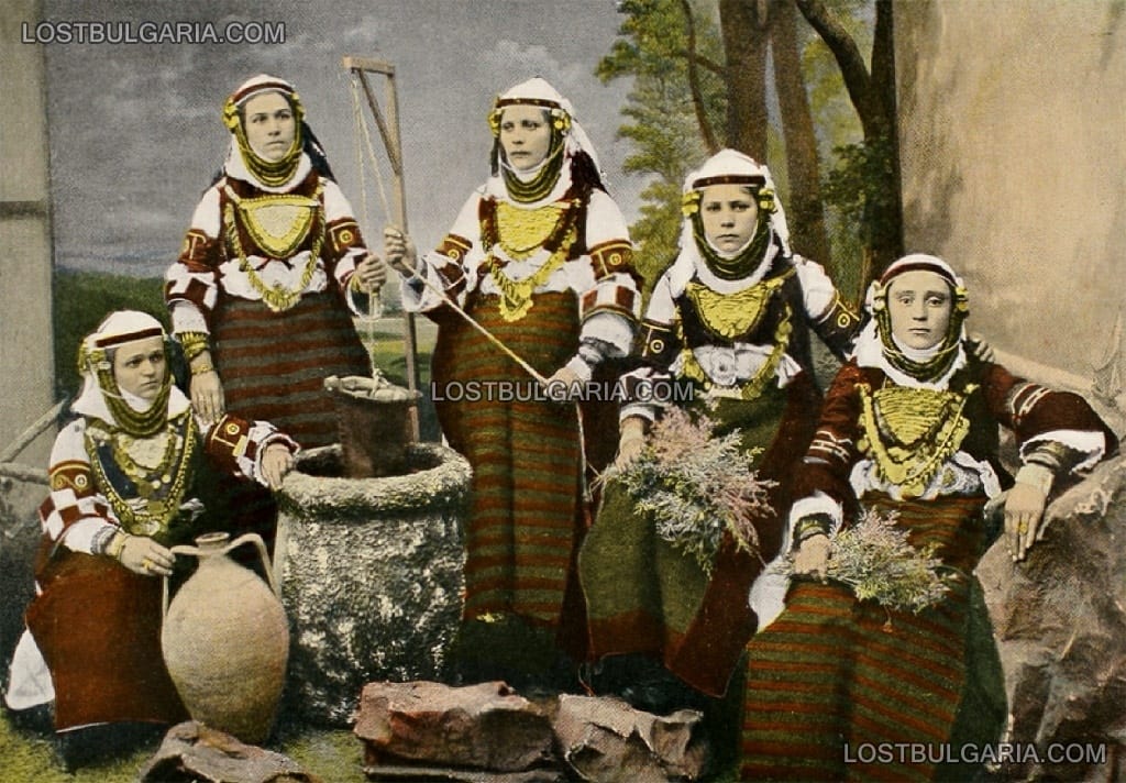 Българки от Македония, облечени в характерни носии, позират пред бутафорен кладенец, началото на ХХ век