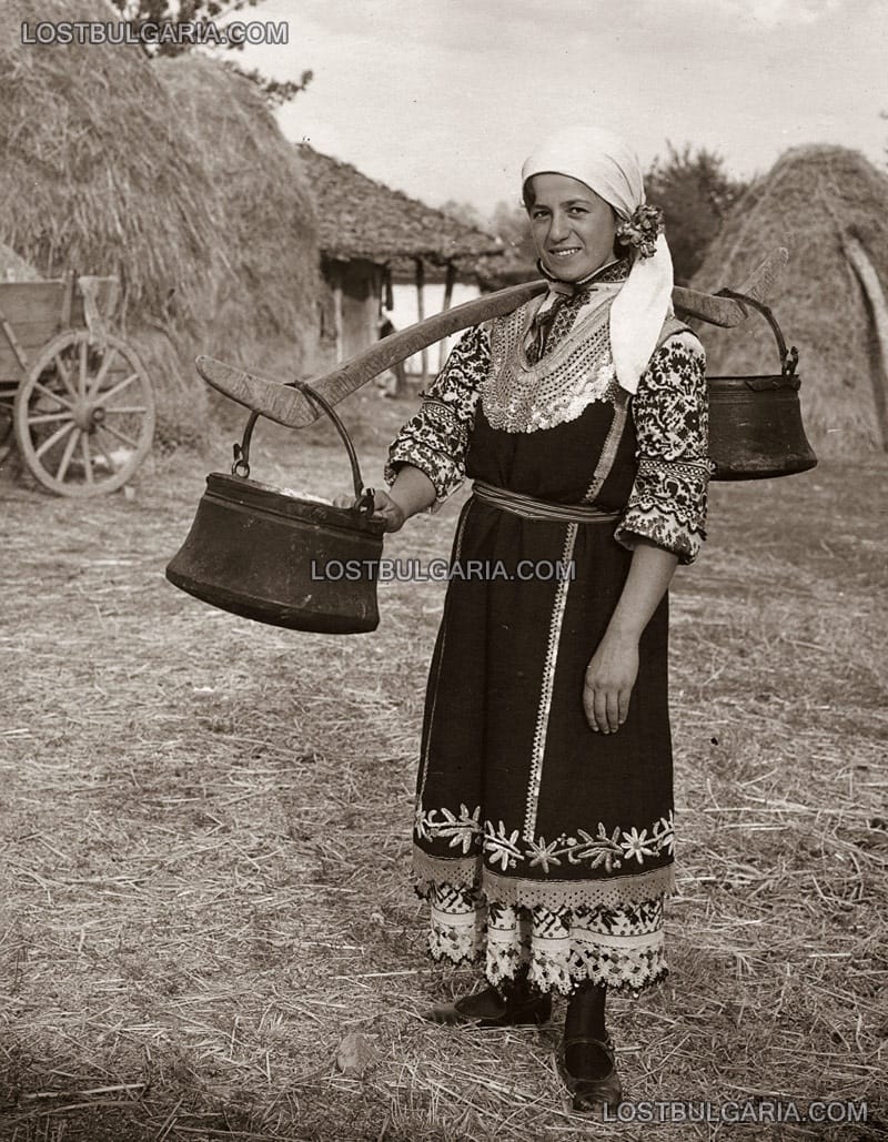 Момиче, облечено в софийска носия носи кобилица с менци за вода, 20-те години на ХХ век