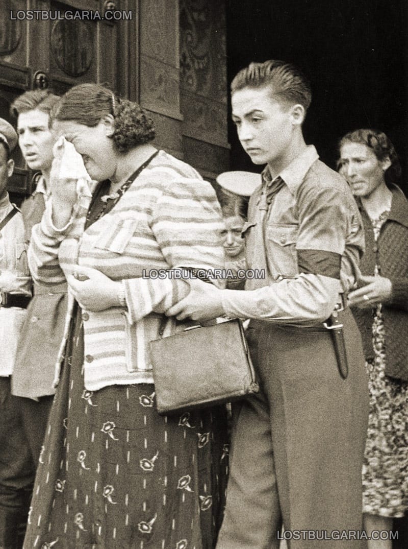 Момче от организацията "Бранник" помага на разплакана жена на излизане от храма "Св. Александър Невски", където е изложено тялото на цар Борис III. София, август 1943 г.