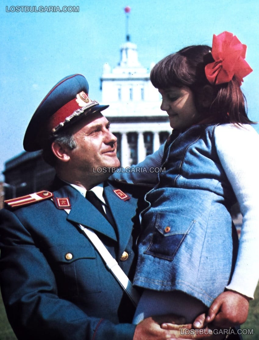Милиционер държи дете пред Партийния дом, София, 60-те години на ХХ век, пропагандна фотография