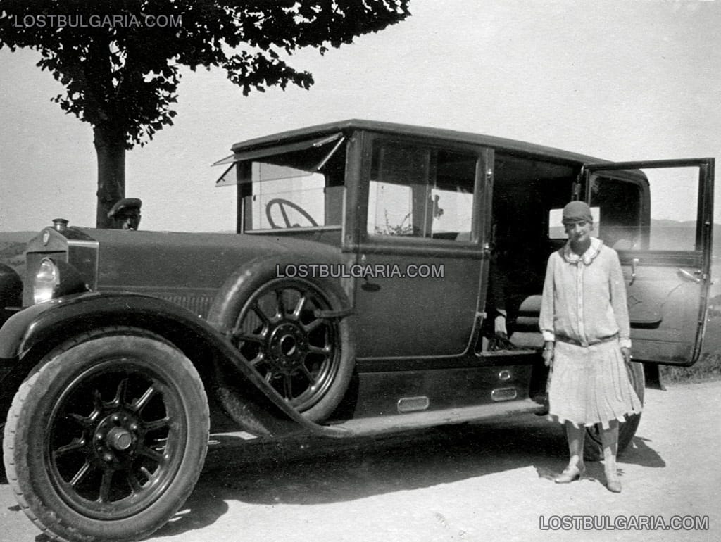 Елегантна дама, облечена в костюм за път до автомобил от 20-те години на ХХ век