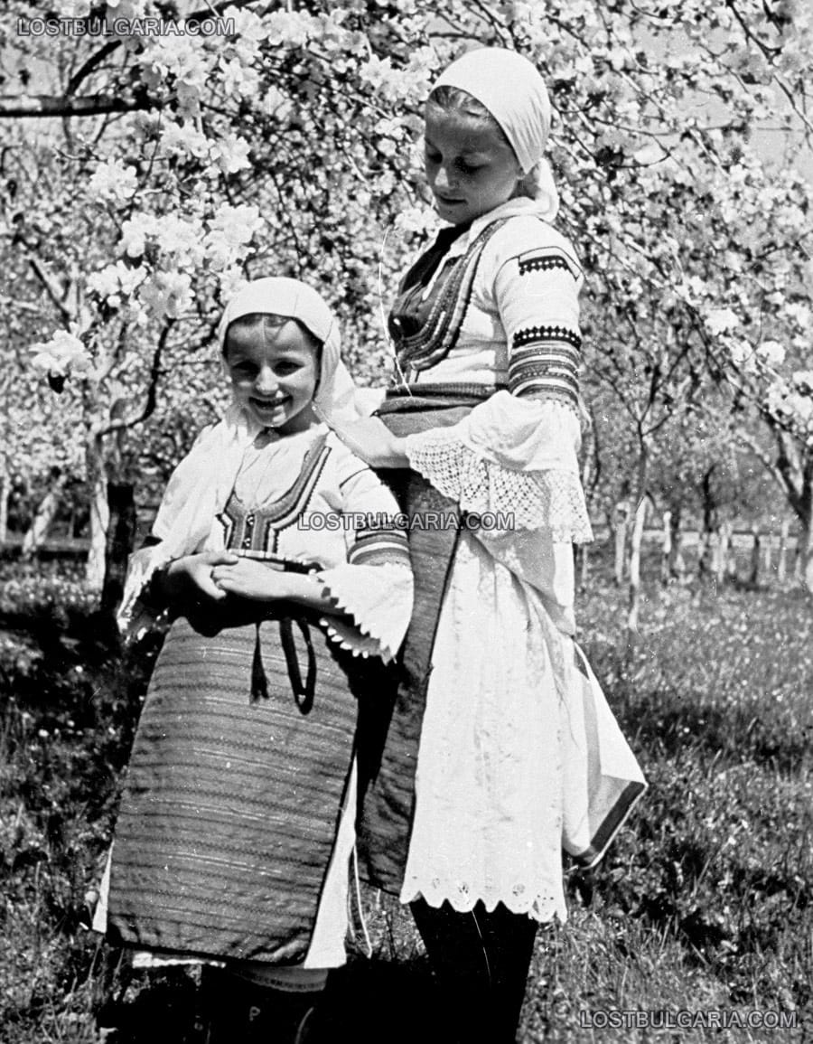Деца, облечени в народни носии сред цъфнала овошна градина, 30-те години на ХХ век