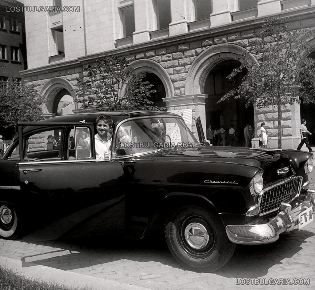Дете позира в автомобил Шевролет (Chevrolet) пред сградата на ЦУМ, 50-те години на ХХ век