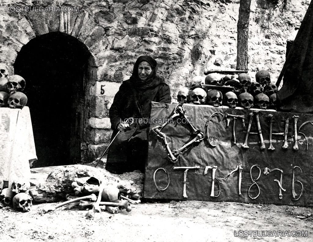 Марга Горанова, оцеляла след Баташкото клане, пред входа на църквата, където е извършено клането. С кости е написано – "Останки от 1876 г.", Батак, 1927 г.﻿