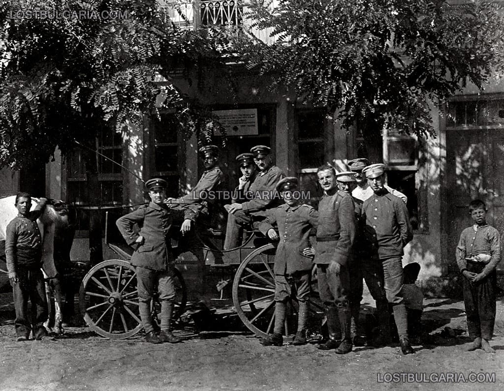 Група германски и български офицери и войници с карета и две местни момчета, вероятно пред щаб на германското командване, някъде в Македония, Първата световна война
