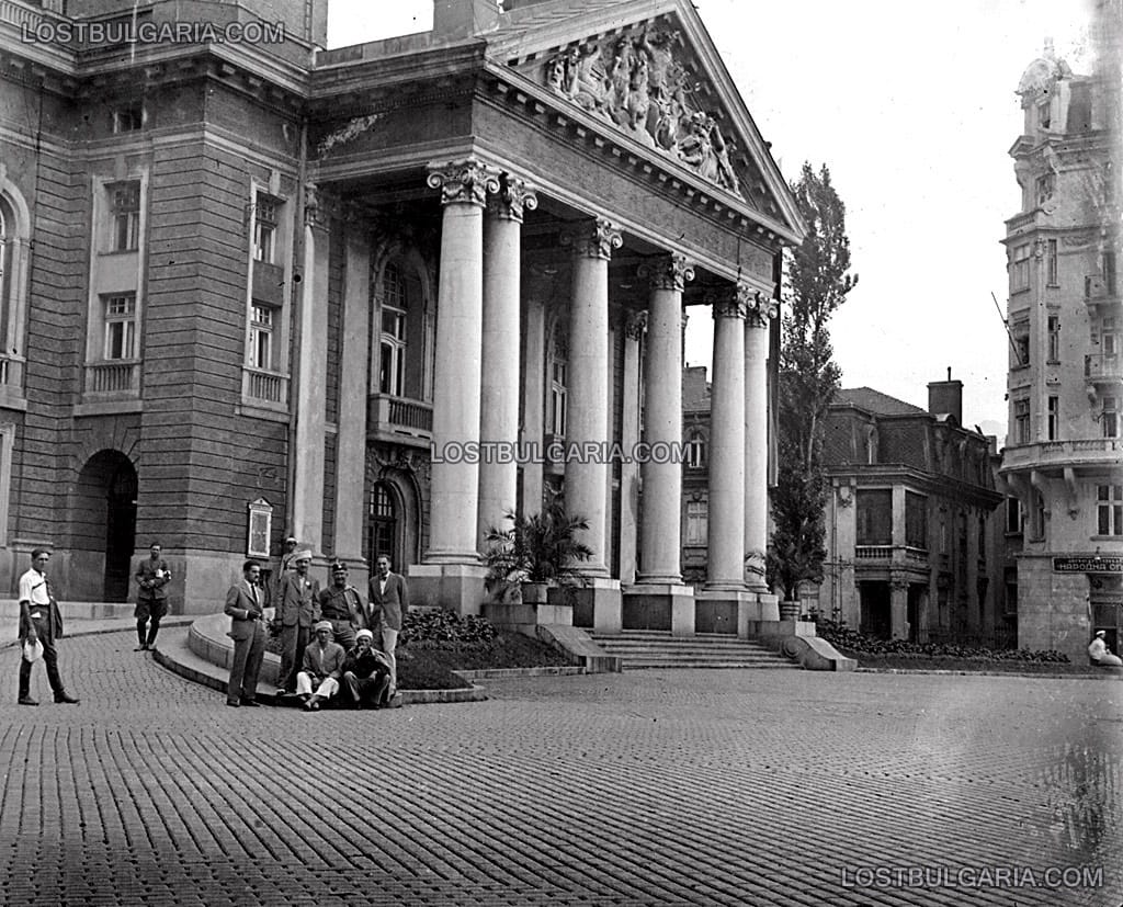Няколко мъже, някои от които облечени в юнашки униформи, пред сградата на Народния театър, вдясно "Аперитив Народна опера", София, края на 20-те години на ХХ век