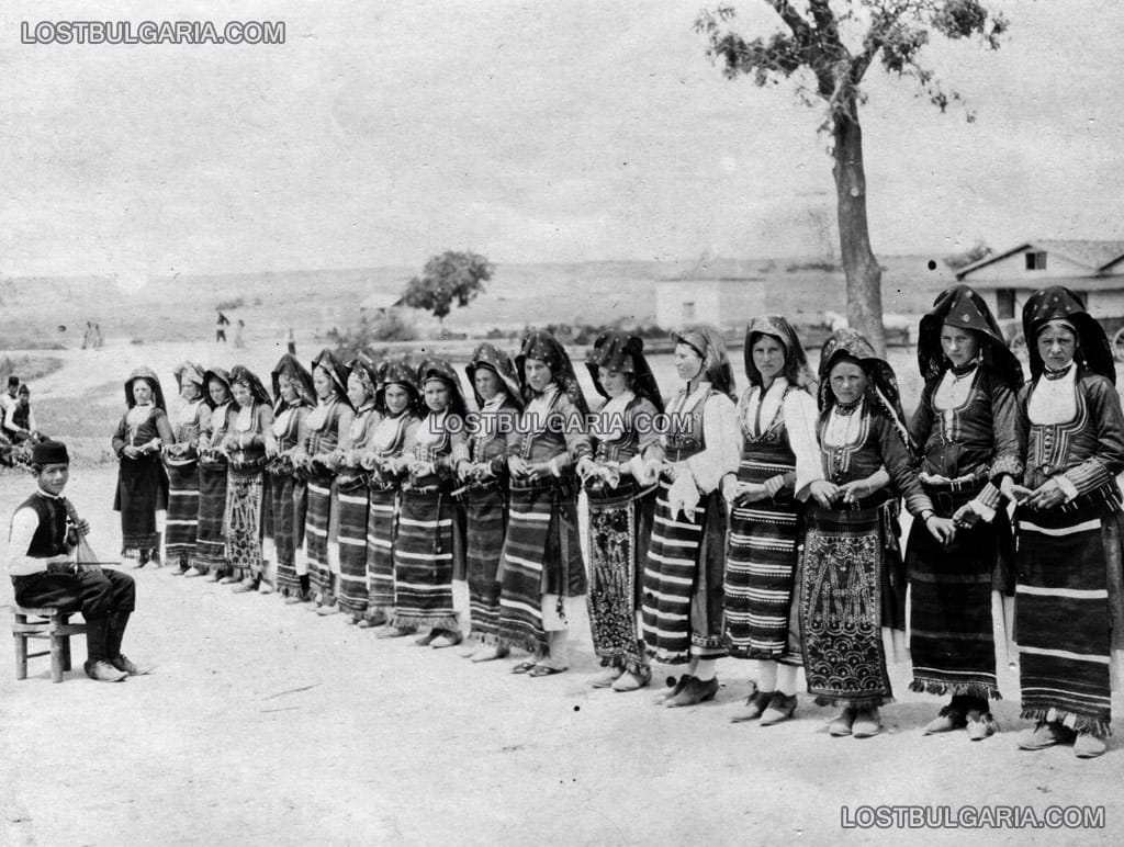 Момче свири на гъдулка на момичета, играещи хоро, вероятно някъде в Македония, около 1912 г.