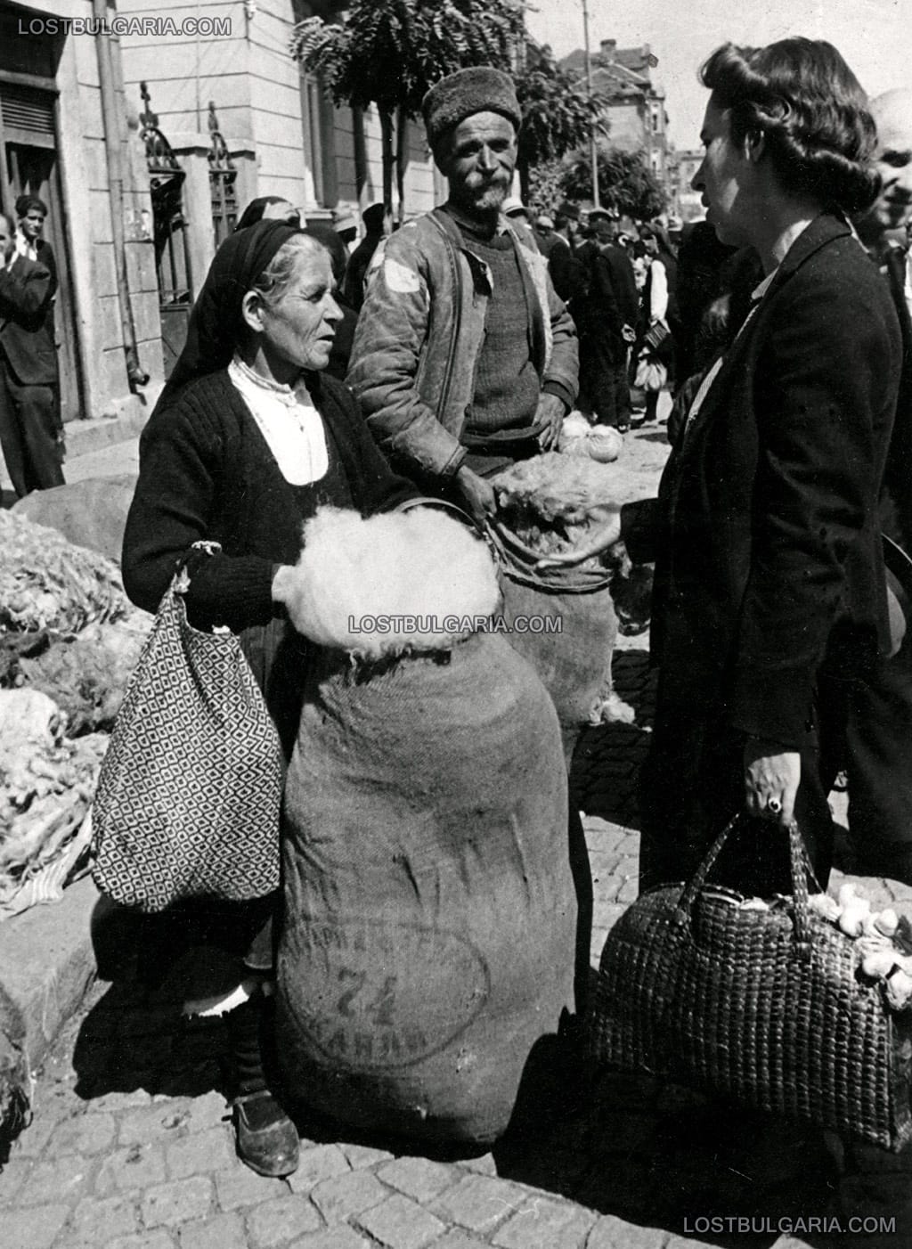 Жена, облечена в градско облекло разговаря с продавачи на вълна, Женския пазар, София, 30-те години на ХХ век