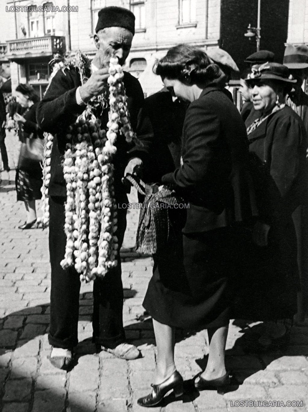 Градски облечена жена пазарува чесън от селяни от софийските села, Женския пазар, София, 30-те години на ХХ век