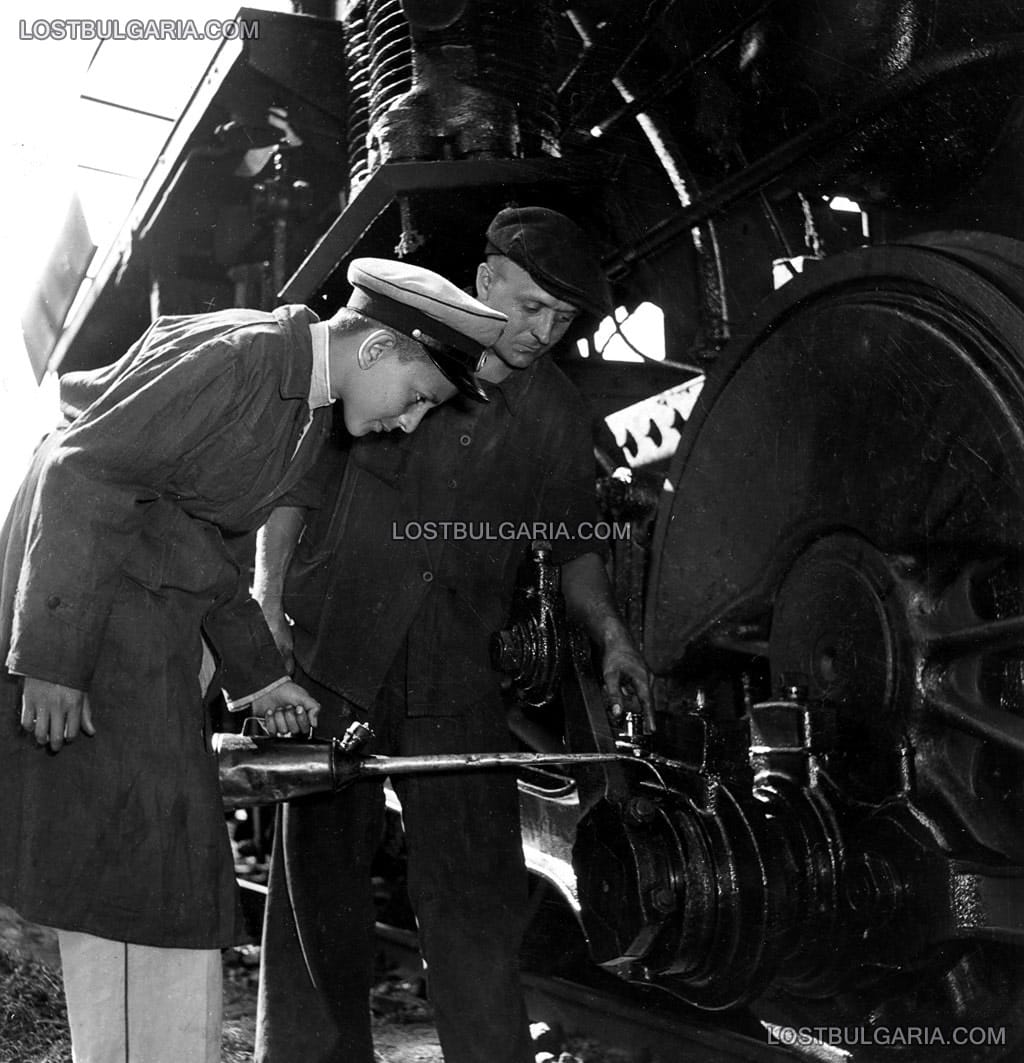 Стаж по железопътно дело - железничар показва на ученик как да подкапва масло на единия от шатунните лагери на локомотива, 50-те години на ХХ век