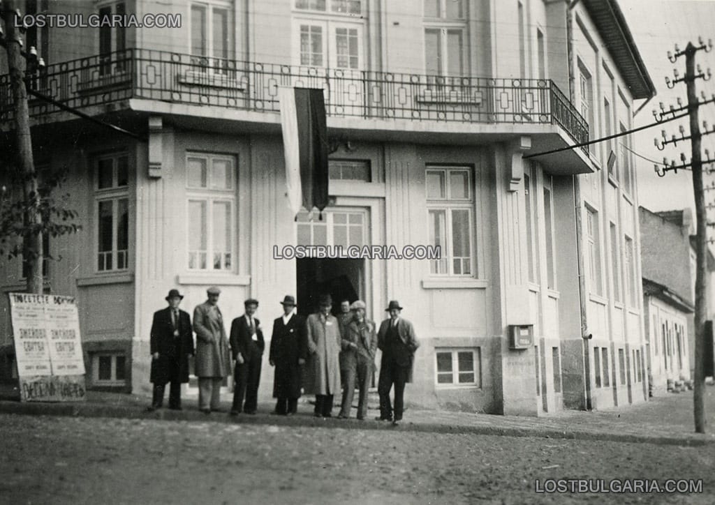 Група мъже пред читалището в Пордим, в ляво се виждат афиши за пиесата "Змейова сватба", 1936 г.