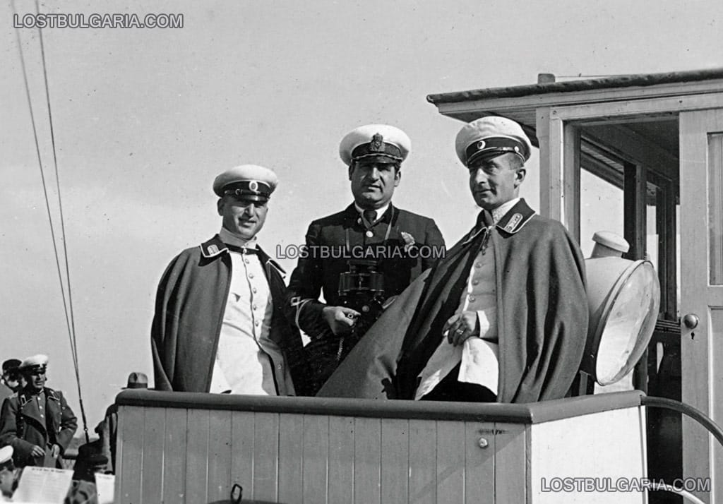 Двама офицери и флотски капитан на мостика на плавателен съд, вероятно по река Дунав, на палубата се вижда духов оркестър, вероятно 30-те години на ХХ век