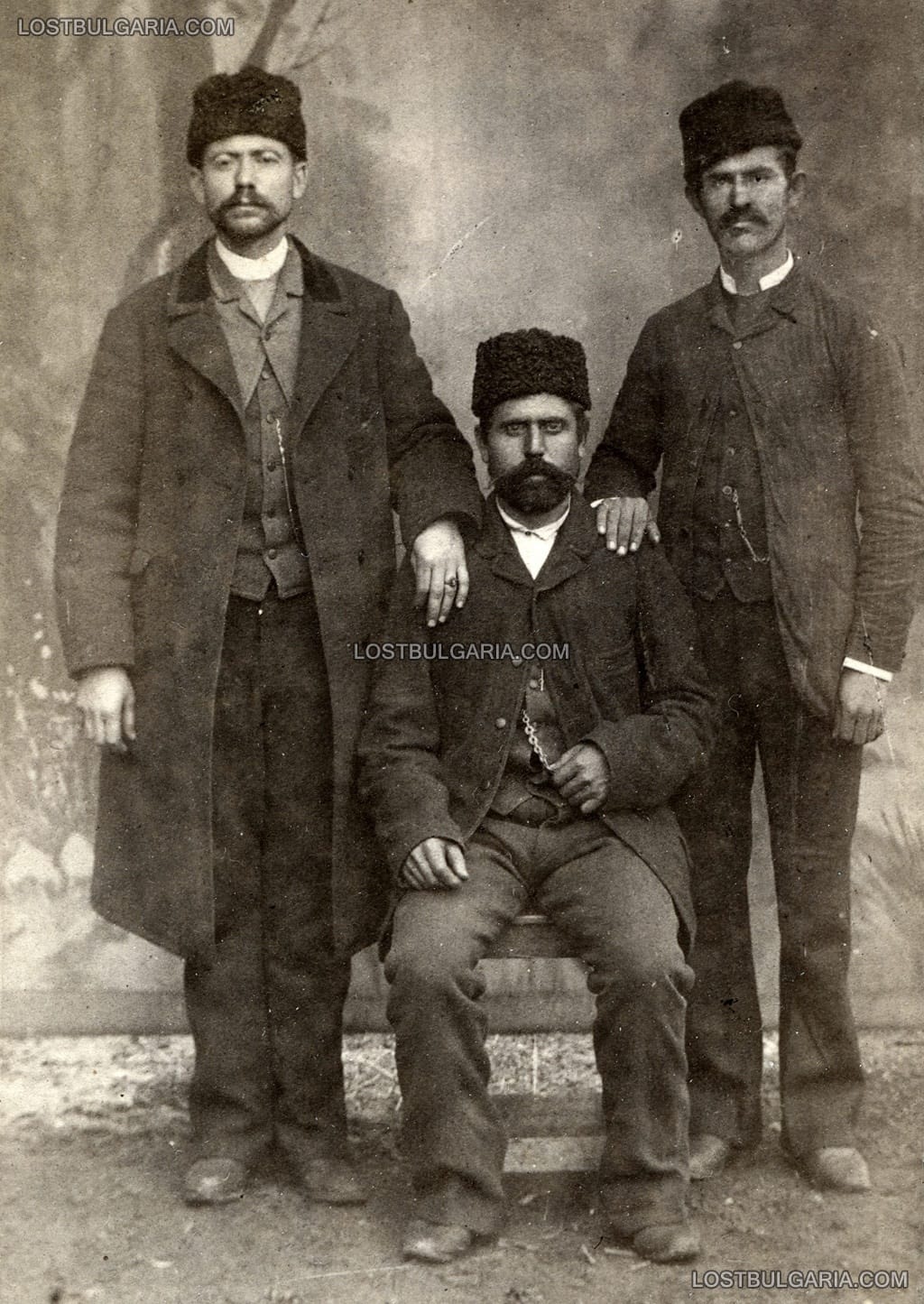 Студиен портрет на трима мъже в градско облекло от края на XIX век. Снимката е надписана: "Старий стражар на 2 участък в София време 1887 по Воскресение ми го подари", София 1887 г.