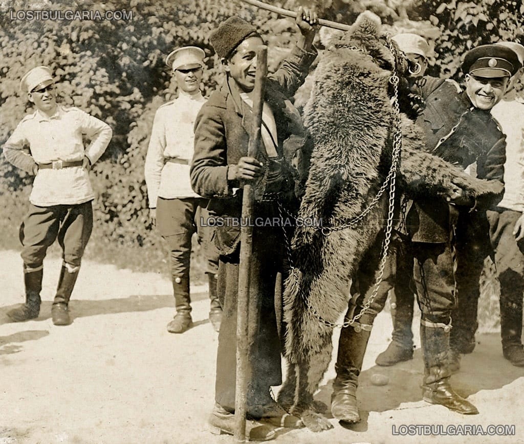 Войници от охраната на двореца "Врана" се снимат за спомен с циганче мечкар и мечката му в парка на двореца, 1925 г.