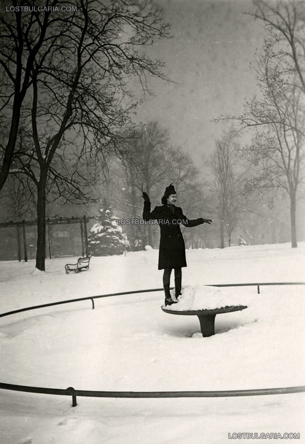 Елегантно облечена млада дама позира върху замръзнал фонтан в Борисовата градина през зимата, София 1936 г.