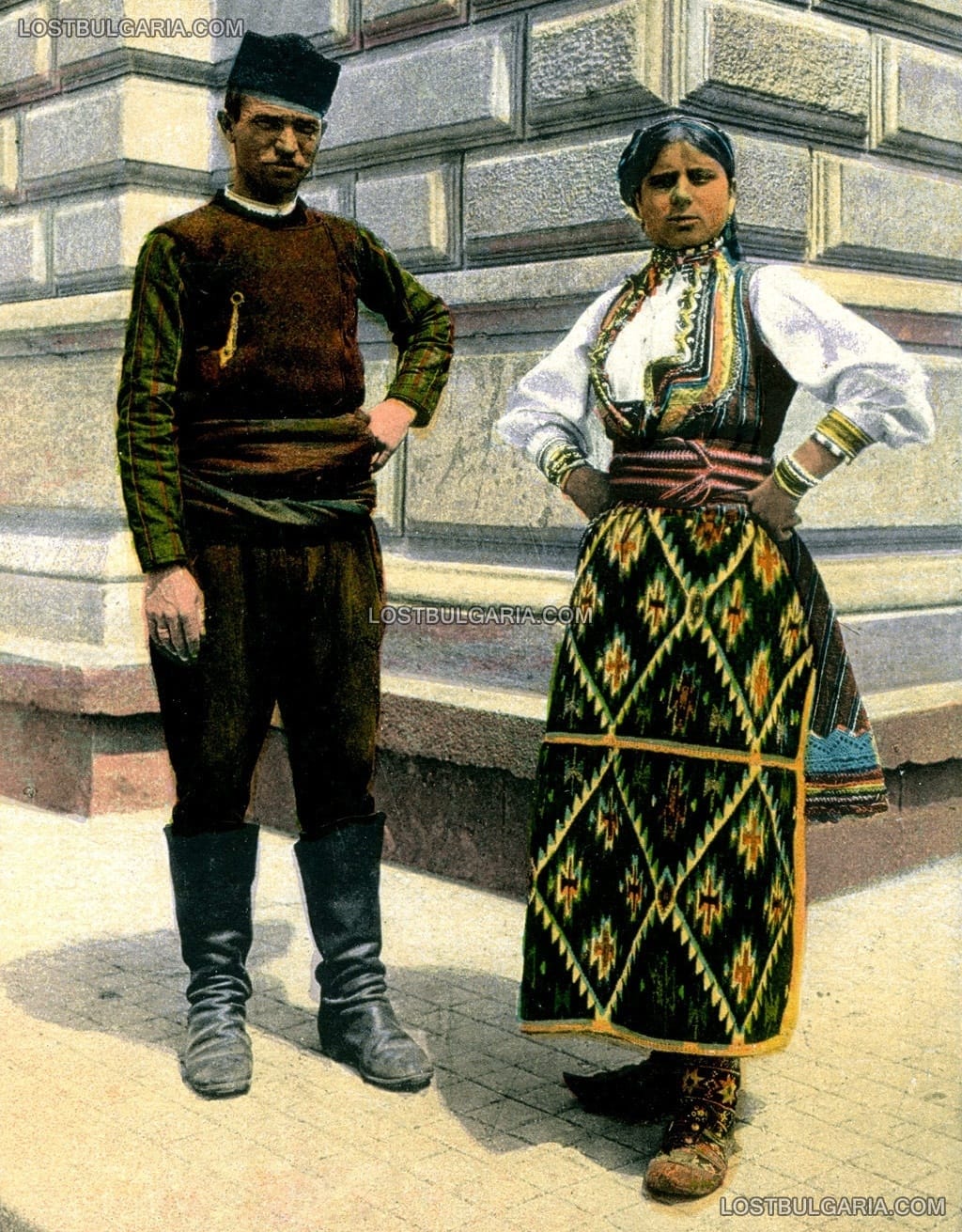 Оцветена фотография на мъж и жена в "неделено" облекло, София началото на ХХ век