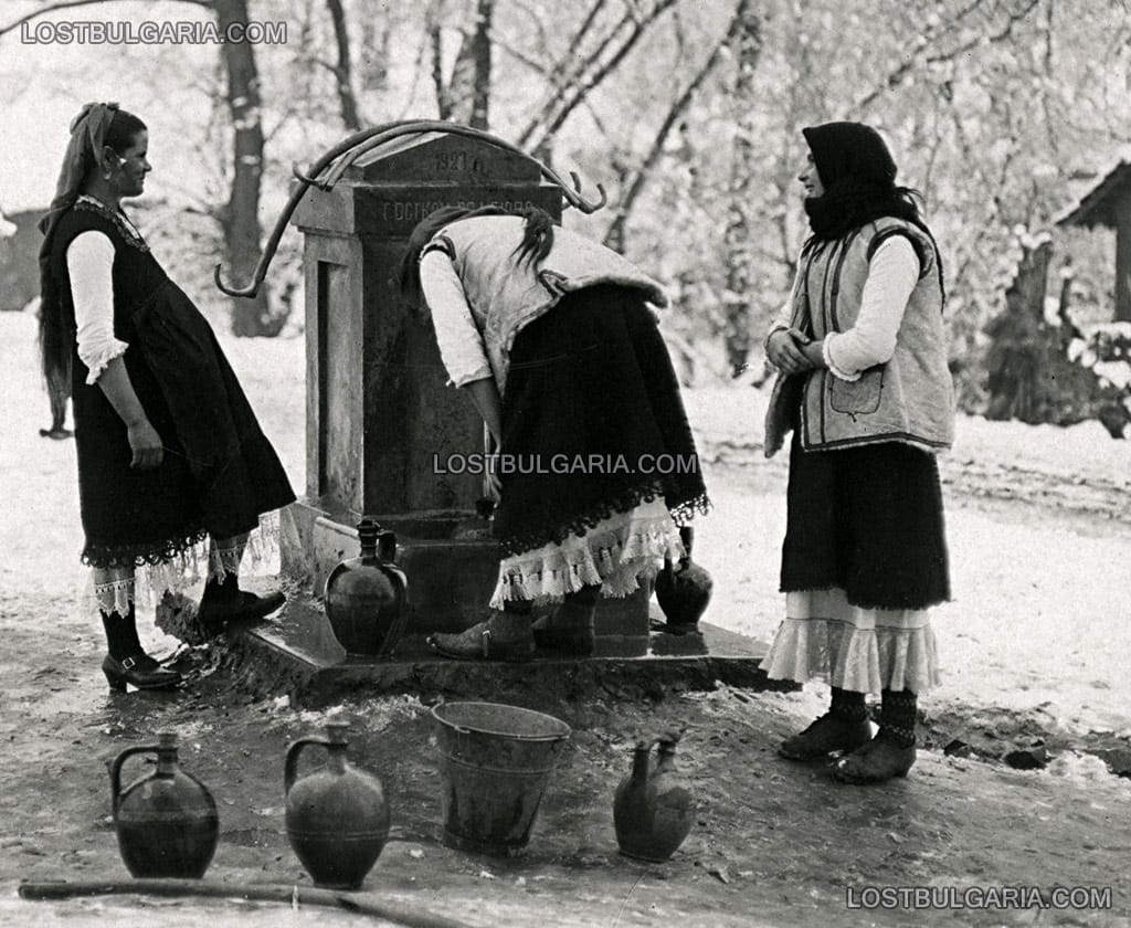 Жени, облечени в носии от Софийско наливат вода в стомни от селската чешма, 20-те години на ХХ век