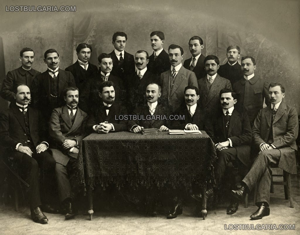 Надписана: "Чиновниците на Б.Н.Банка в Татар Пазарджик, снимани по случай изпращането на стария и посрещането на новия директор на клона. Крайния отдясно на първия ред е Александър Стоев Диканев. Снимката станала през 1910 година."