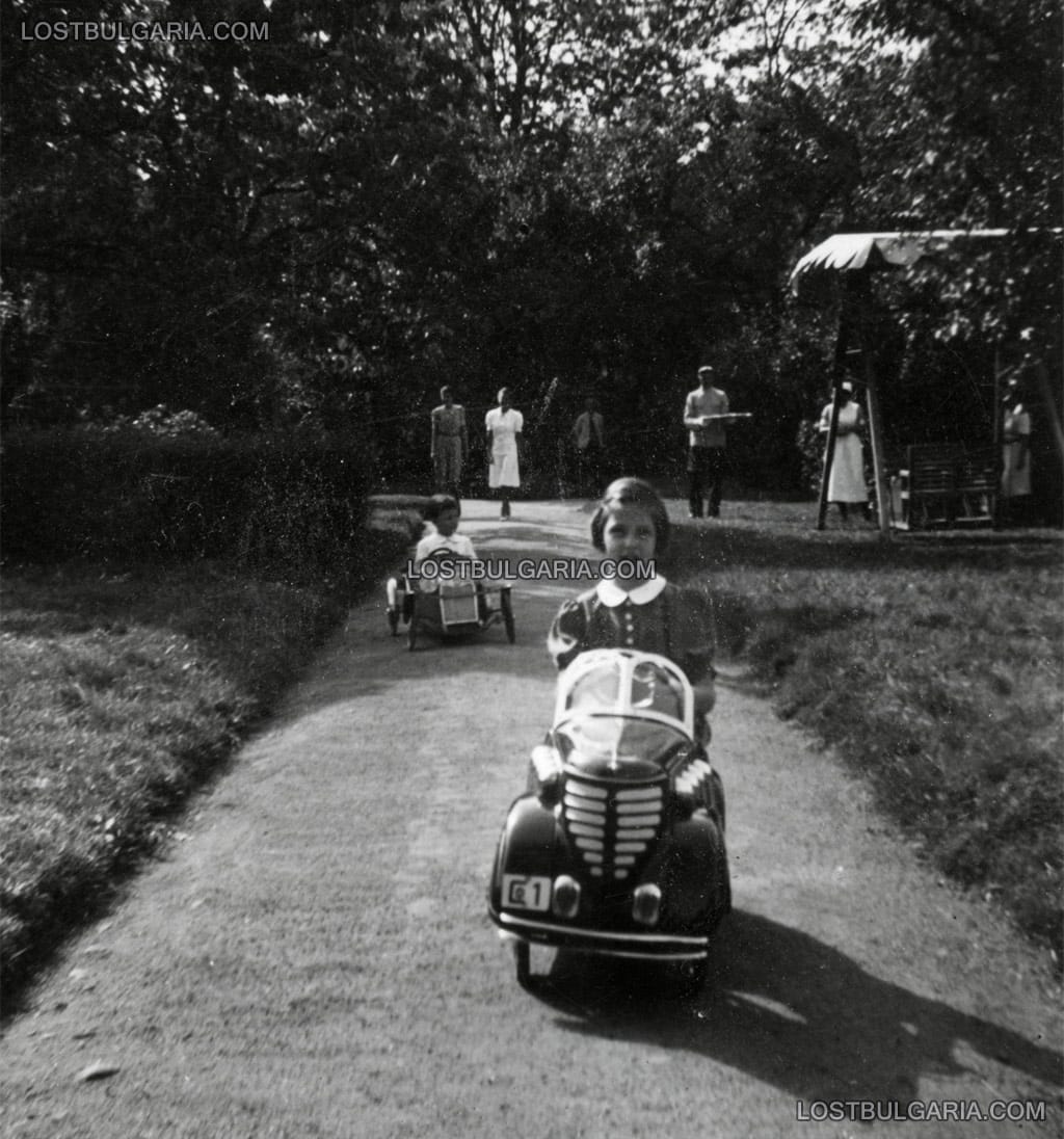 Княгиня Мария Луиза с детски автомобил с педали, на заден план престолонаследникът княз Симеон. Парка на двореца Враня, месец юни 1941 г.