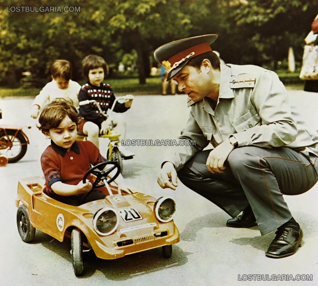 Фотография, показваща служител на КАТ (контрол по автотранспорта) да обяснява правилата за движение по пътищата, 80-те години на ХХ век