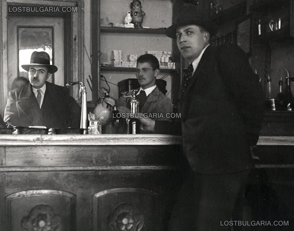 Елегантно облечени мъже и барман на бара в пивница, неизвестно къде, 30-те години на ХХ век